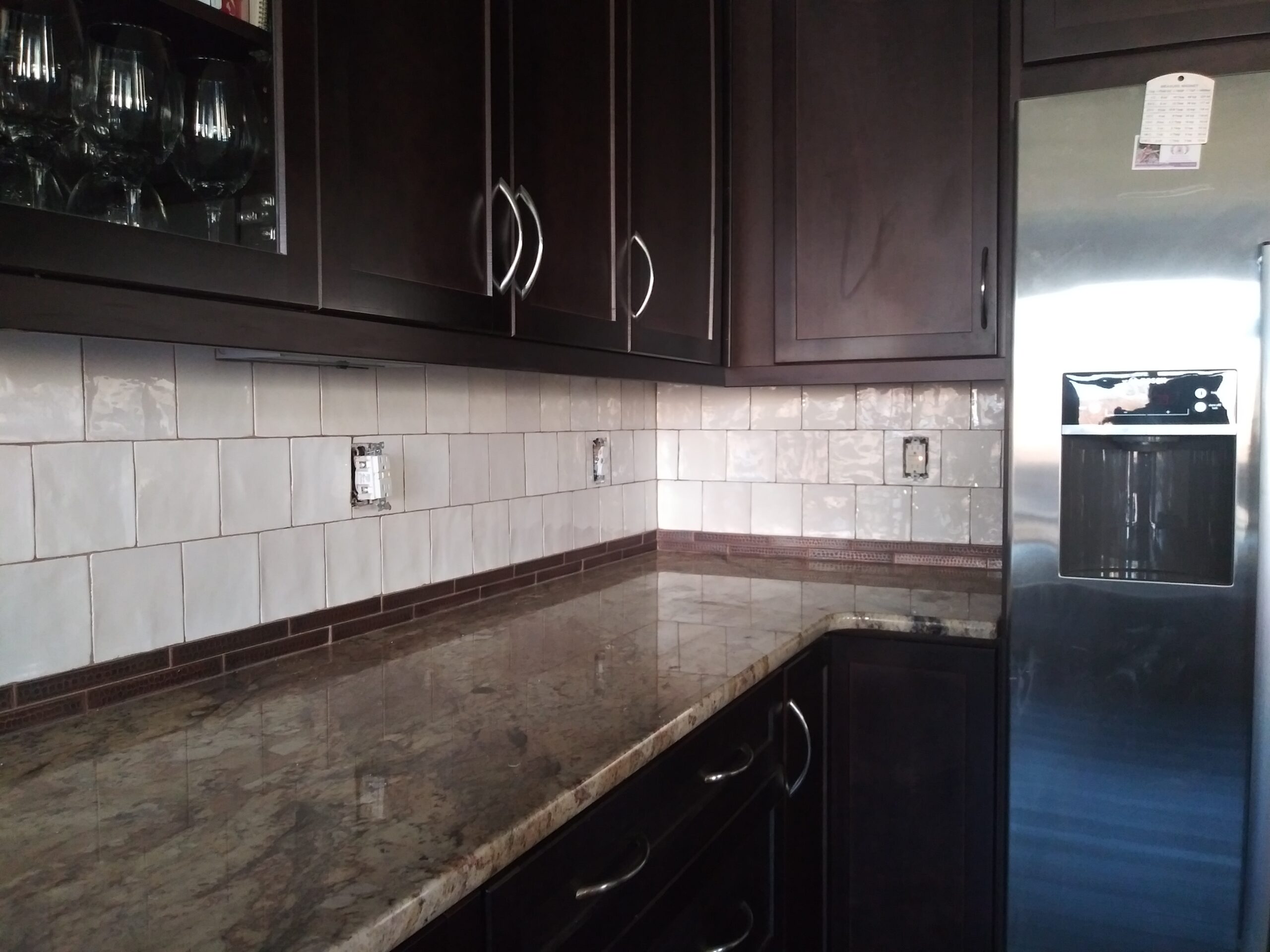 Close-up of handmade subway tile with copper accent